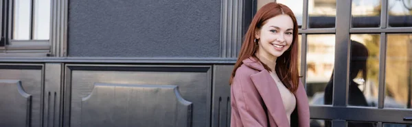 Mujer Pelirroja Feliz Abrigo Elegante Sonriendo Cerca Edificio Moderno Pancarta —  Fotos de Stock