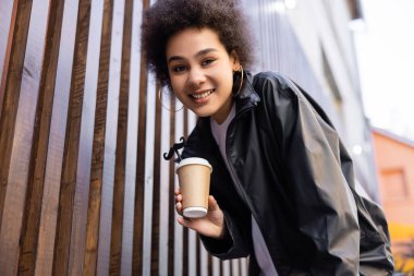 Düşük açılı, mutlu Afro-Amerikan kadını elinde yiyecek ve saman bıyıklı.