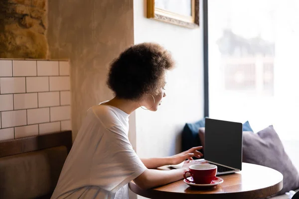 Curly African American Woman Using Laptop Blank Screen Cup Coffee — Fotografia de Stock