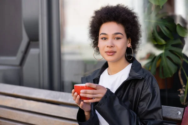 Curly African American Woman Holding Cup Coffee While Sitting Bench — Foto Stock