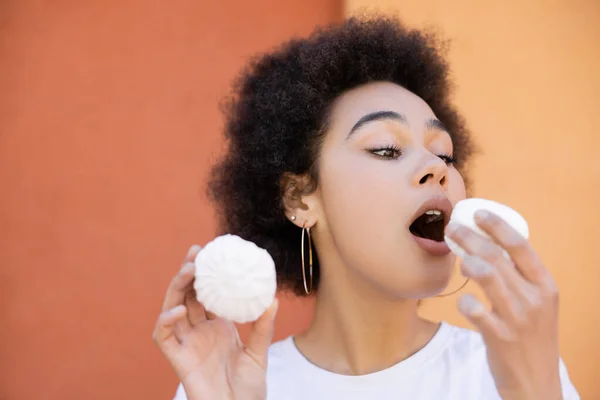 African American Woman Open Mouth Holding Zefir Orange Wall — стоковое фото