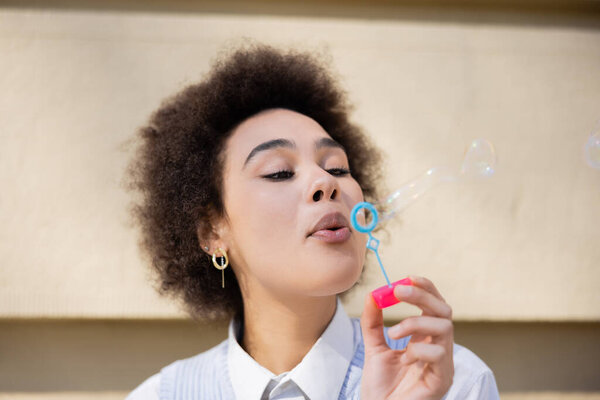 young african american woman blowing soap bubbles