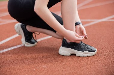 Siyah spor ayakkabı bağlayan sporcu kadın manzarası 