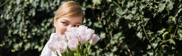 Blonde Smiling Woman Obscuring Face White Tulips Green Ivy Banner — Stock Photo, Image