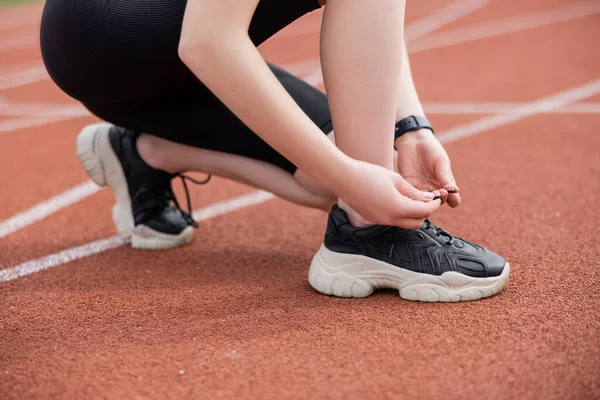 Siyah spor ayakkabı bağlayan sporcu kadın manzarası 