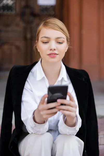 Молода Блондинка Білій Сорочці Використовує Мобільний Телефон Відкритому Повітрі — стокове фото