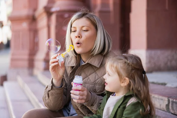 Moeder Blazen Zeepbellen Buurt Van Kleine Dochter Straat — Stockfoto