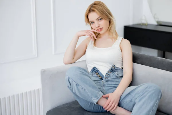 Sonriente Mujer Descalza Jeans Mirando Cámara Sofá — Foto de Stock