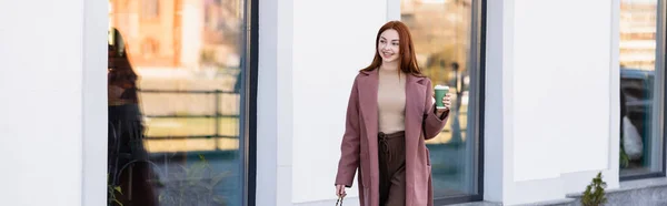 Glücklich rothaarige Frau mit Handtasche hält Pappbecher auf der städtischen Straße, Banner — Stockfoto