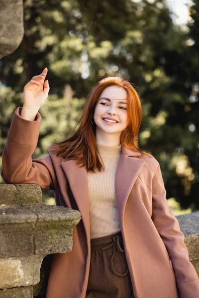 Portrait of happy redhead woman in coat outside — Stock Photo