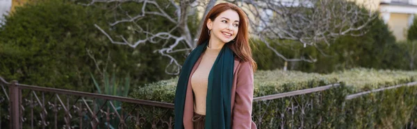 Happy young woman in coat with scarf looking away, banner — Photo de stock