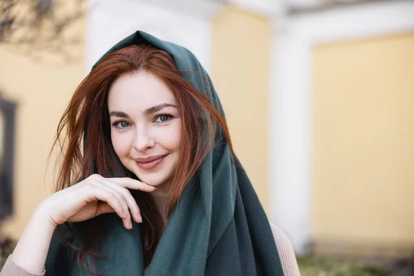 Retrato de jovem ruiva mulher em lenço de cabeça sorrindo enquanto olha para a câmera — Fotografia de Stock