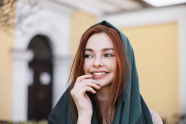 Retrato de la joven mujer alegre en pañuelo para la cabeza sonriendo mientras mira hacia otro lado - foto de stock