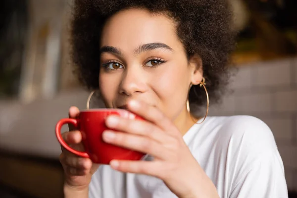 Крупным планом молодая африканская американка держит чашку кофе — стоковое фото