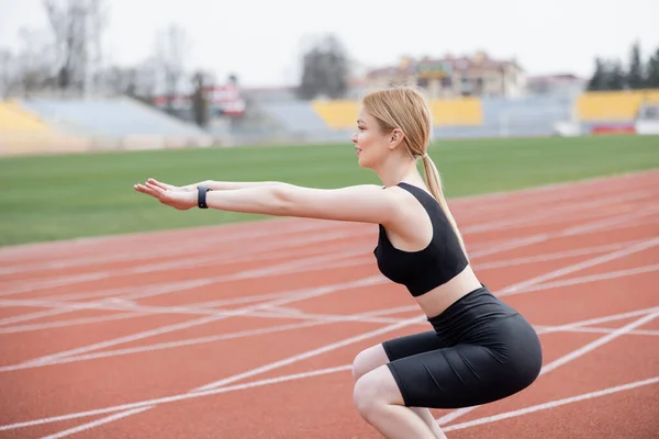 Vista lateral de la deportista haciendo sit ups con las manos extendidas - foto de stock