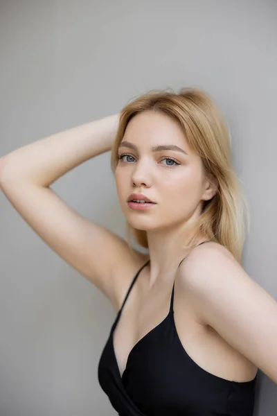 Retrato de mulher loira bonita no vestido olhando para a câmera no fundo cinza — Fotografia de Stock