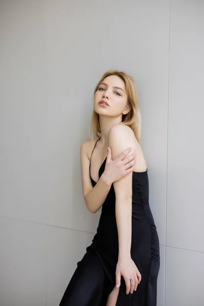 Young woman in black dress looking at camera at home — Stock Photo