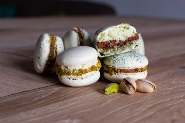 Ev yapımı şam fıstığı ve ahşap masaya istiflenmiş çikolatalı badem kurabiyesi.