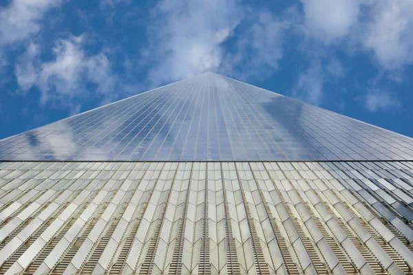 NEW YORK - CIRCA EPTEMBER, 2017: One World Trade binasının önündeki cam gökyüzündeki bulutları yansıtıyor