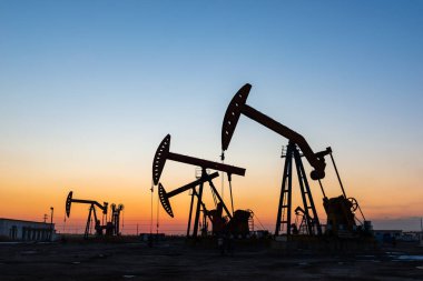 Petrol pompaları akşamları çalışıyor, yağ pompası silueti.