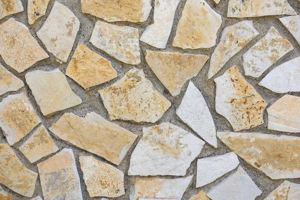 Stone masonry wall surface. Rock pieces and concrete mosaic wall background. Rough stone textured background. Brickwork backdrop.