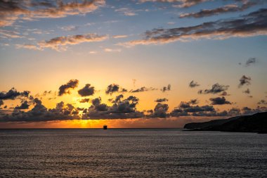 Gün batımında denizin üzerinde bulutlar arasında inanılmaz güneş ve ışınlar..