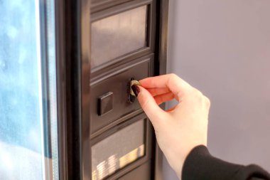 İnsan eli otomata bozuk para yerleştiriyor..