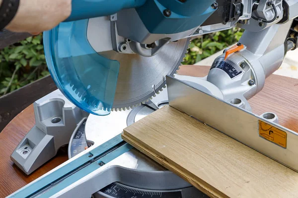 Miter saw in the process of sawing off a wooden part. Close up