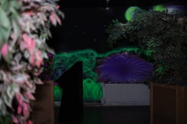 Duvarlarda floresan duvar yazıları olan bir lazer oyunu iç mimarisi.