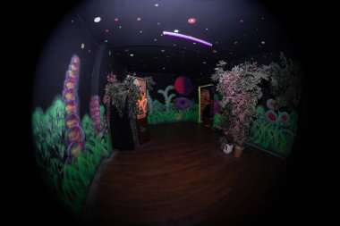 Duvarlarda floresan duvar yazıları olan bir lazer oyunu iç mimarisi.