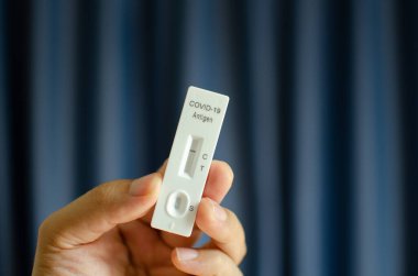 Mavi zemin üzerinde koronavirüs için antijen hızlı test kiti üzerinde covid-19 negatif test gösteriliyor.