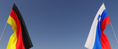 Mavi arka planda bayrak direkleri üzerinde Almanya ve Slovenya bayrakları. Mesaj için yer. Rüzgarda dalgalanan bayraklar. Alman, Berlin. Ljubljana. 3d illüstrasyon.