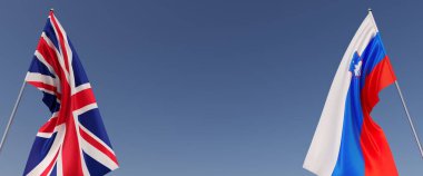 Büyük Britanya ve Slovenya bayrakları bayrak direğine asıldı. Mavi arka planda bayraklar. Mesaj için yer. İngiltere, Londra. Birleşik Krallık. Ljubljana. Bağımsız Devletler. 3B illüstrasyon.