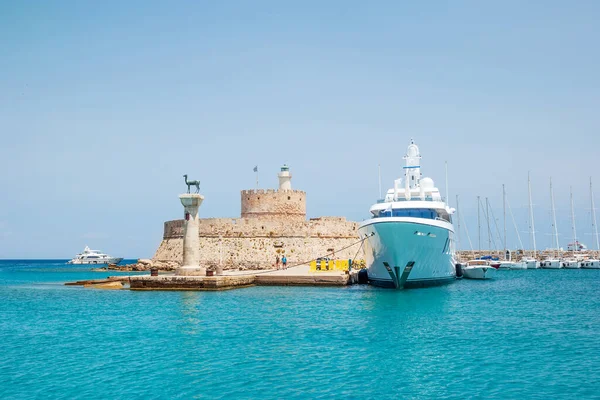 Mandraki limanının girişindeki Agios Nikolaos Kalesi (Aziz Nikolaos Kalesi) ve ön plandaki sütundaki geyik heykeli.