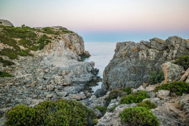Yunanistan 'ın Rodos kentindeki Anthony Quinn Körfezi yakınlarında gün batımında Rocky sahili.