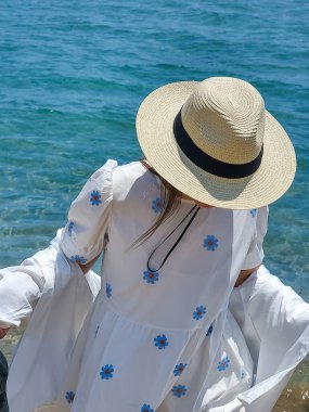 Hasır şapkalı kız, Yunanistan 'ın Rodos adasındaki Anthony Quinn Koyu' nda yüzüyor..