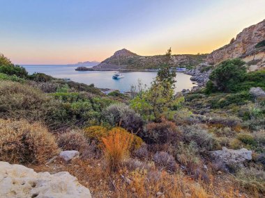 Yunanistan 'ın Rodos kentindeki Anthony Quinn Körfezi yakınlarında gün batımında Rocky sahili.