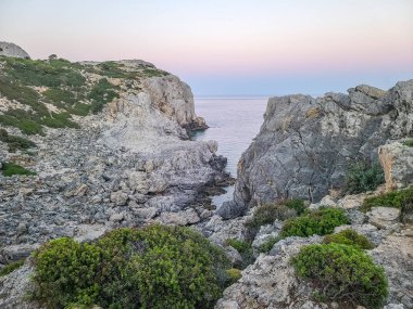 Yunanistan 'ın Rodos kentindeki Anthony Quinn Körfezi yakınlarında gün batımında Rocky sahili.