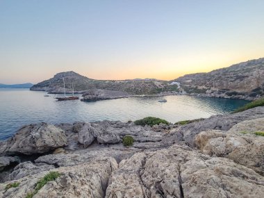 Yunanistan 'ın Rodos kentindeki Anthony Quinn Körfezi yakınlarında gün batımında Rocky sahili.