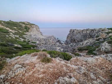 Yunanistan 'ın Rodos kentindeki Anthony Quinn Körfezi yakınlarında gün batımında Rocky sahili.