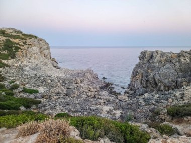 Yunanistan 'ın Rodos kentindeki Anthony Quinn Körfezi yakınlarında gün batımında Rocky sahili.