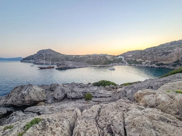 Yunanistan 'ın Rodos kentindeki Anthony Quinn Körfezi yakınlarında gün batımında Rocky sahili.