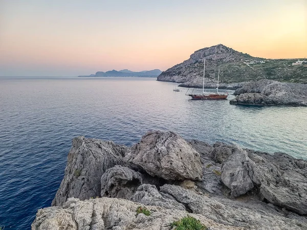 Yunanistan 'ın Rodos kentindeki Anthony Quinn Körfezi yakınlarında gün batımında Rocky sahili.