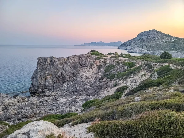 Yunanistan 'ın Rodos kentindeki Anthony Quinn Körfezi yakınlarında gün batımında Rocky sahili.