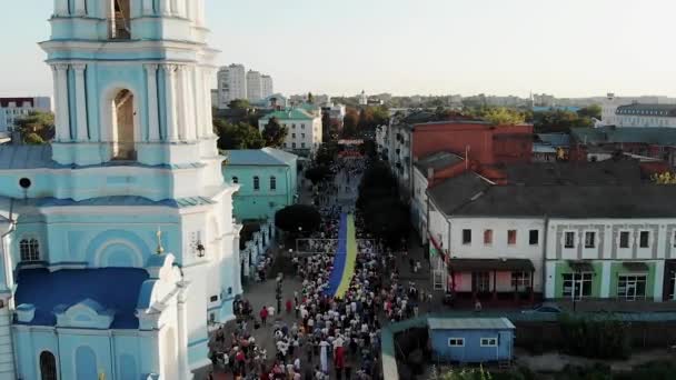 サムイ島でウクライナの巨大な旗を運ぶ多くの人々のドローンショット Spaso Preobrazhensky大聖堂ウクライナ ウクライナの独立記念日 国民だ スミーの正教会 — ストック動画
