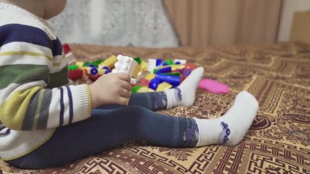 Gyereket Játékokkal Játsszák Kisfiú Összeszereli Kivitelezőt Ágyon Sokszínű Játékszerek Apró — Stock videók