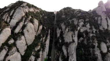 Teleferiğin insansız hava aracı görüntüsü Montserrat dağına. Montserrat Manastırı 'na tırmanmak. Funicular 'dan Montserrat Manastırı' na. Ulaşım şekli, dağlardaki cazibe.