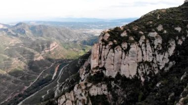 Montserrat Dağı 'ndaki St. Michael Haçı' nın insansız hava aracı görüntüleri. Kayalık bir çıkıntının kenarında bir haç. Katalonya. Montserrat 'ın kutsal dağı ve manastırı. Resimli dağlar. Dağ patikaları.
