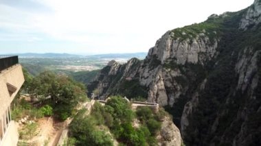 İspanya 'daki Montserrat Dağı. Montserrat 'ın ünlü manastırı. Benedikt rahiplerinin dağ inzivası. Tırtıklı dağ. Turistler dağlardaki bir manastırı ziyaret ediyorlar
