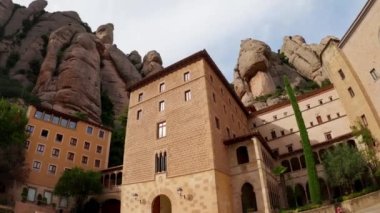 İspanya 'daki Montserrat Dağı. Montserrat 'ın ünlü manastırı. Benedikt rahiplerinin dağ inzivası. Tırtıklı dağ. Turistler dağlardaki bir manastırı ziyaret ediyorlar